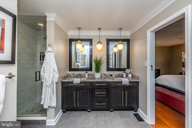 full bathroom featuring double vanity, a stall shower, baseboards, and ornamental molding