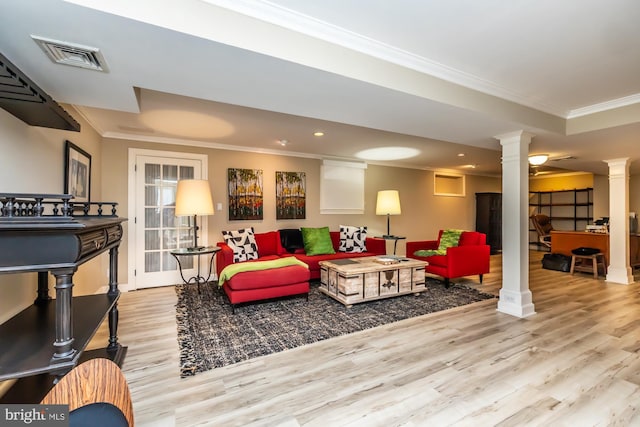 living room with decorative columns, wood finished floors, visible vents, and ornamental molding