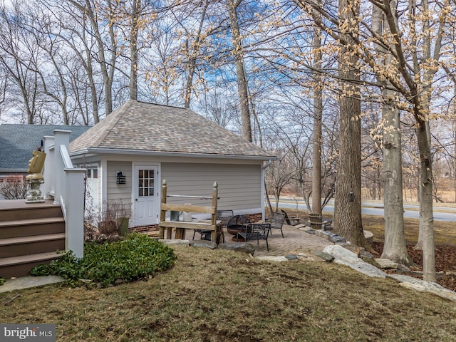 back of property featuring a lawn and a shingled roof