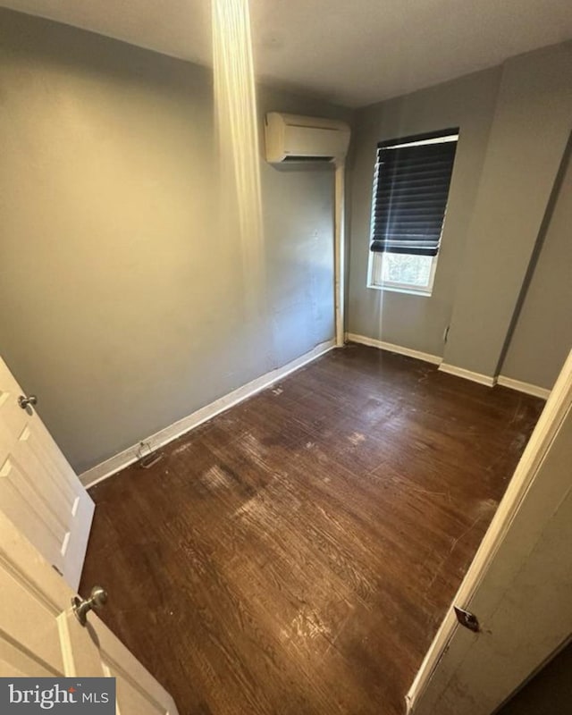 2837 Stouton St, Philadelphia, PA 19134 - empty room with a wall mounted AC, baseboards, and dark wood finished floors