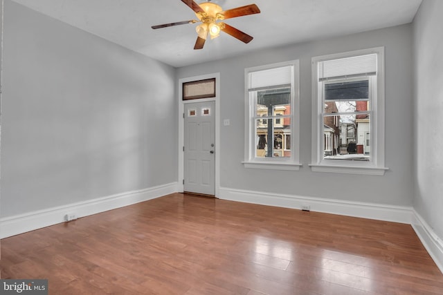 interior space featuring wood finished floors, baseboards, and ceiling fan