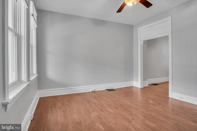 spare room with wood finished floors, baseboards, and ceiling fan