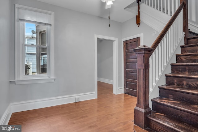 interior space featuring baseboards, wood finished floors, and a ceiling fan