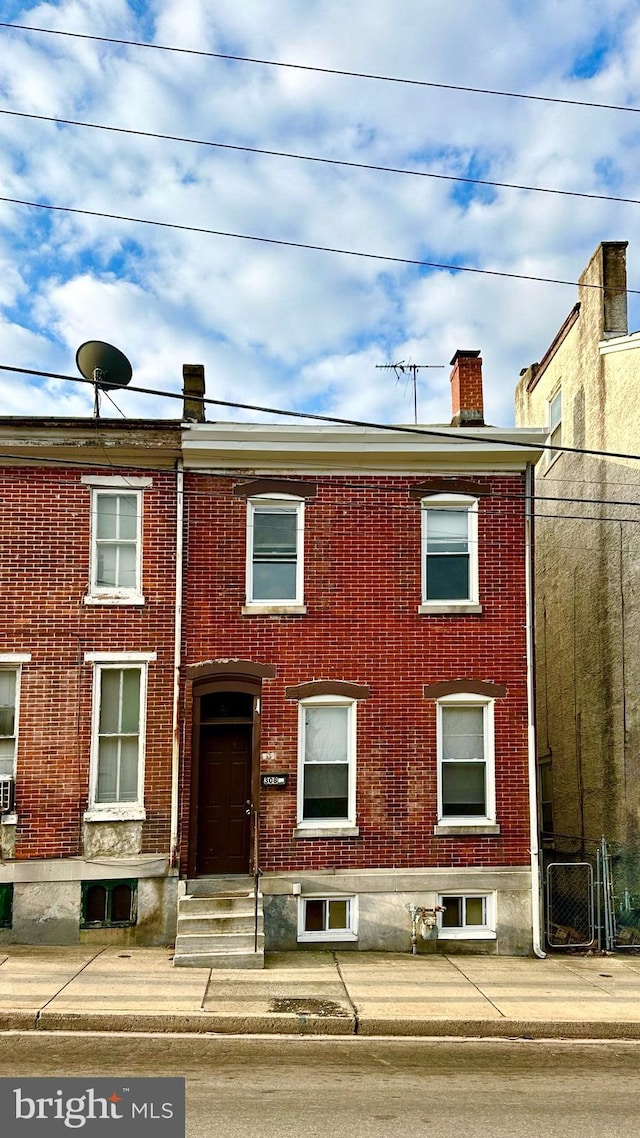 multi unit property featuring brick siding and a chimney