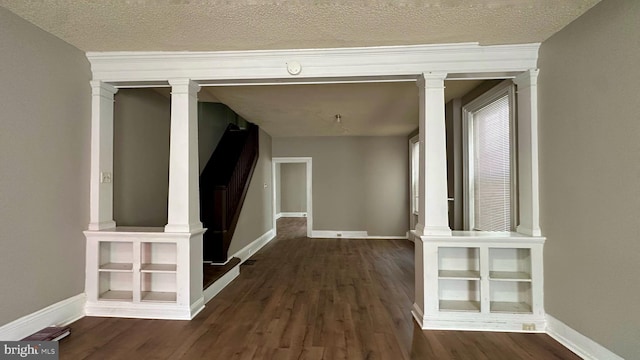 hallway with a textured ceiling, wood finished floors, and baseboards