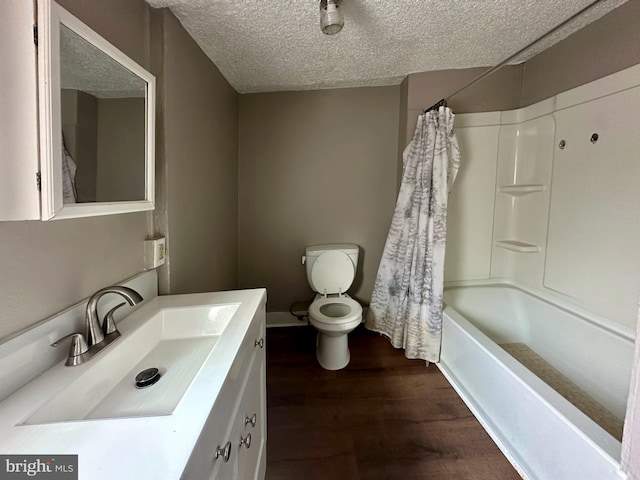 bathroom featuring a textured ceiling, toilet, wood finished floors, vanity, and shower / bath combo with shower curtain