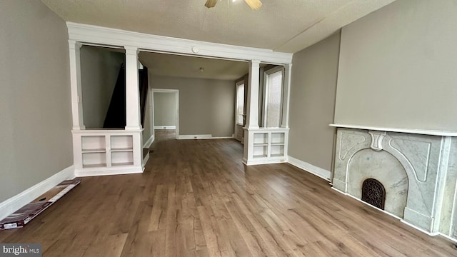 unfurnished living room with a ceiling fan, baseboards, and wood finished floors