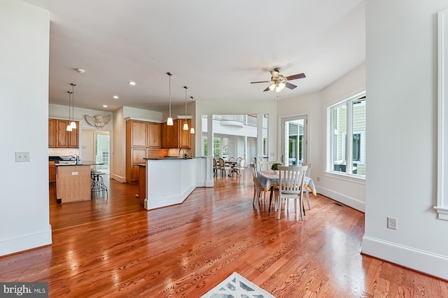 kitchen featuring baseboards, dark countertops, light wood-style floors, pendant lighting, and recessed lighting