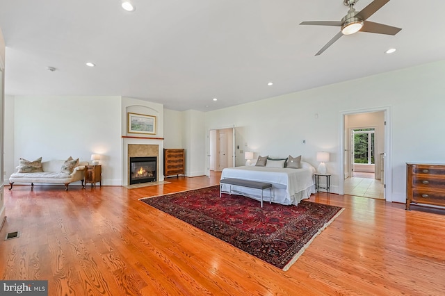 bedroom featuring recessed lighting, visible vents, a fireplace with flush hearth, wood finished floors, and baseboards