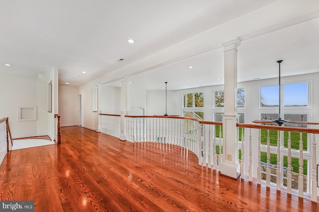 unfurnished room featuring ceiling fan, wood finished floors, decorative columns, and recessed lighting