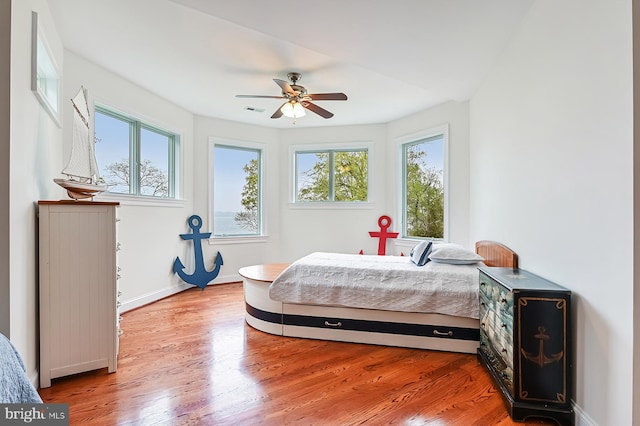 bedroom featuring visible vents, ceiling fan, light wood-style flooring, and baseboards