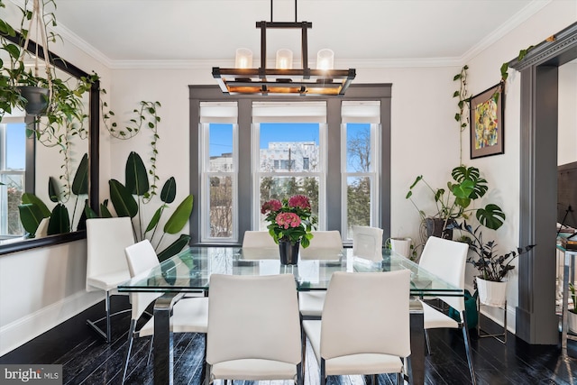 dining room featuring crown molding, a notable chandelier, baseboards, and dark wood-type flooring