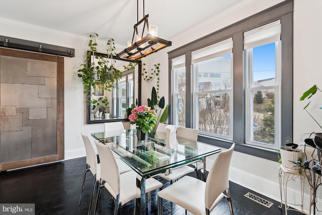 dining room with dark wood-style floors, visible vents, baseboards, and ornamental molding