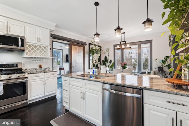 kitchen featuring ornamental molding, appliances with stainless steel finishes, dark wood-style floors, white cabinets, and a sink