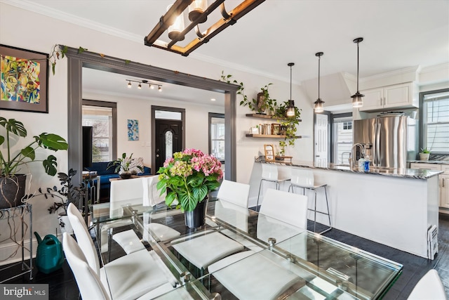 dining room with crown molding, dark wood-style flooring, and a chandelier