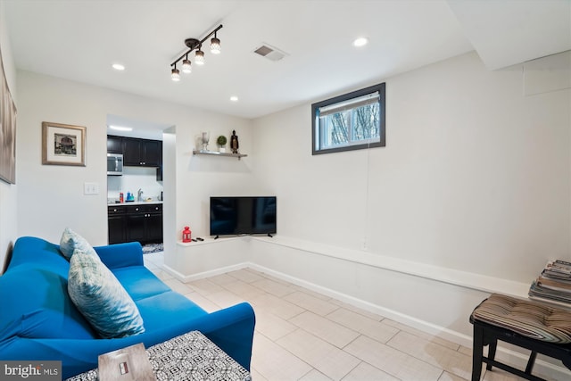 living area featuring light tile patterned floors, baseboards, visible vents, recessed lighting, and rail lighting