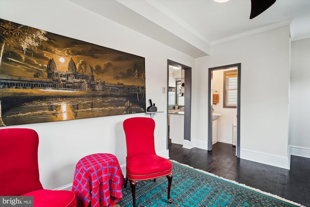 living area with crown molding, wood finished floors, and baseboards