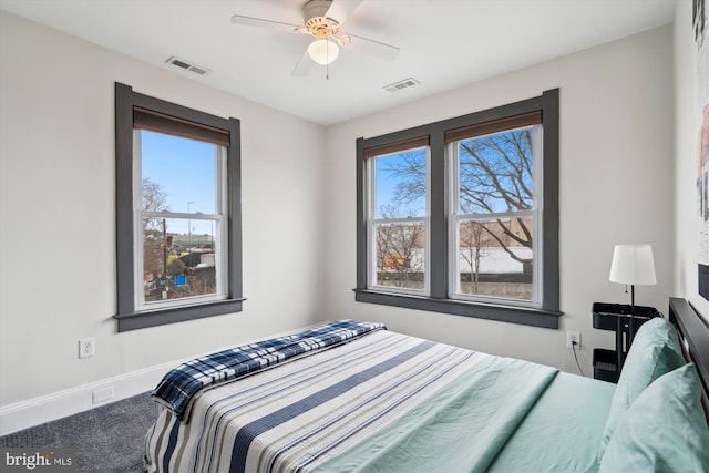 carpeted bedroom featuring visible vents, a ceiling fan, and baseboards