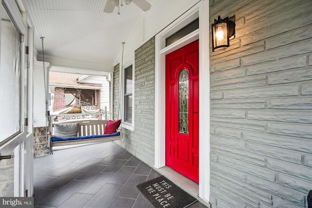 doorway to property with brick siding and covered porch