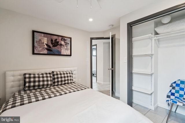 bedroom with light tile patterned floors, recessed lighting, baseboards, and a closet