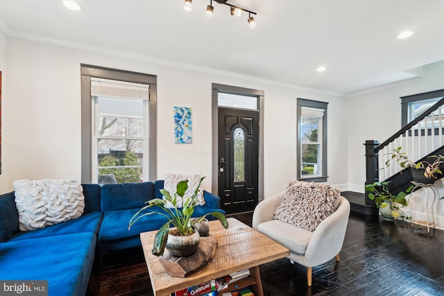 living area with a healthy amount of sunlight, stairs, and crown molding