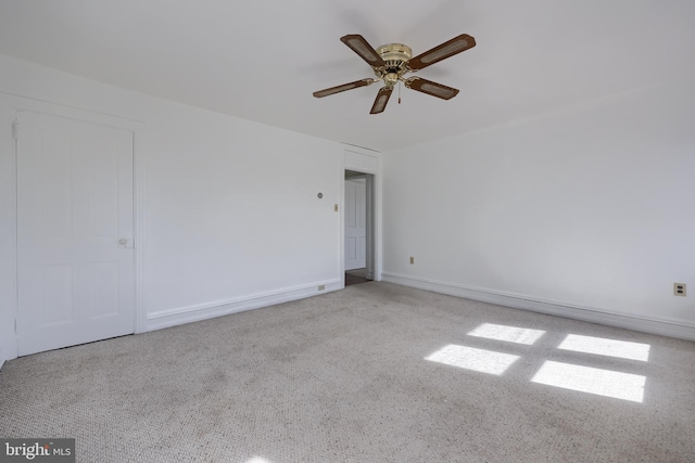 spare room with ceiling fan and baseboards