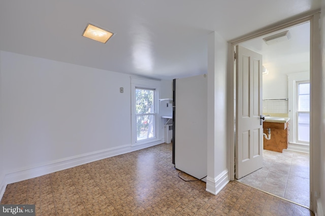 spare room with light floors, baseboards, and visible vents