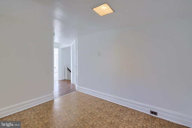 spare room with tile patterned floors and baseboards