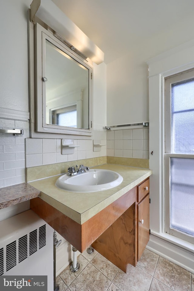 bathroom featuring tile patterned flooring, vanity, and tile walls