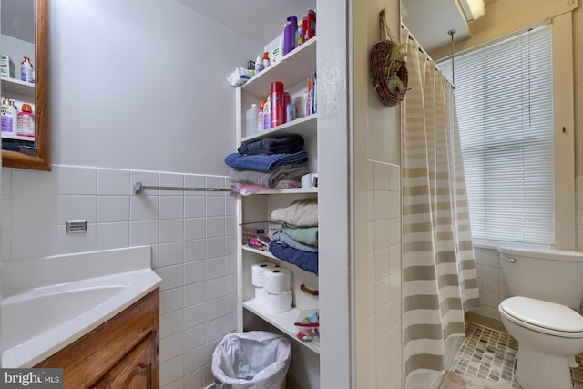 full bathroom featuring tile walls, toilet, vanity, a shower with curtain, and tile patterned floors