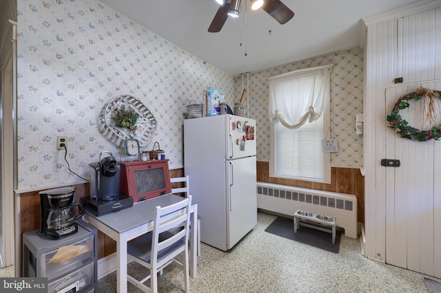 home office with radiator, wallpapered walls, ceiling fan, and a wainscoted wall