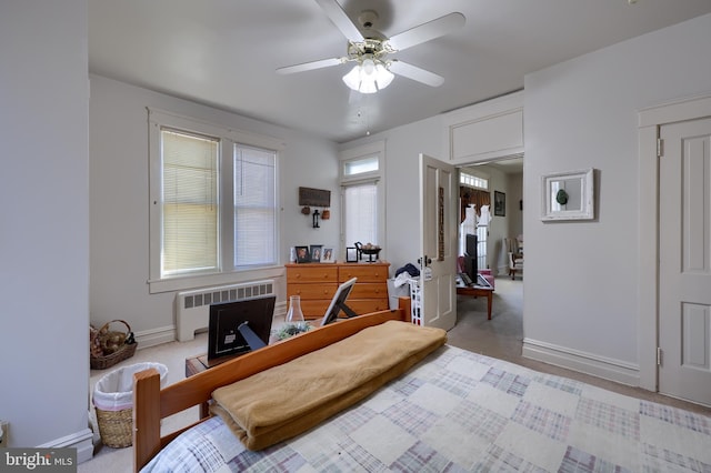 bedroom featuring ceiling fan, radiator heating unit, and baseboards