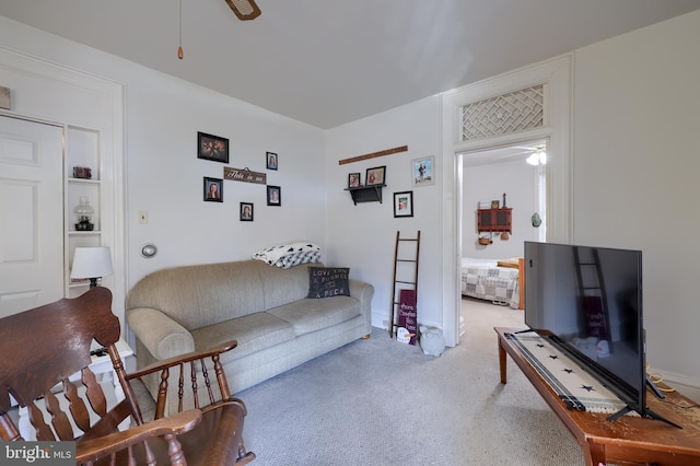 living area with ceiling fan and light carpet