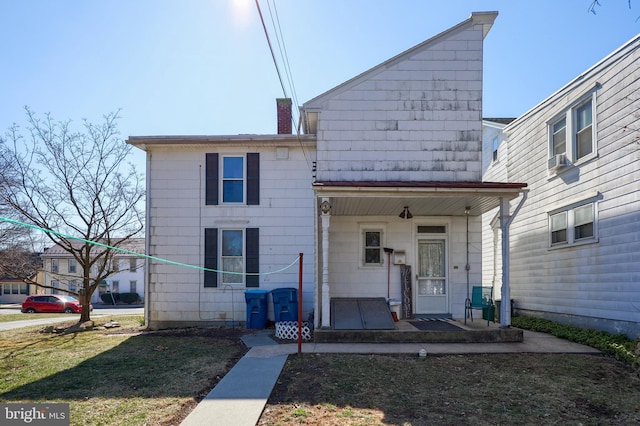 back of property with a lawn and a chimney