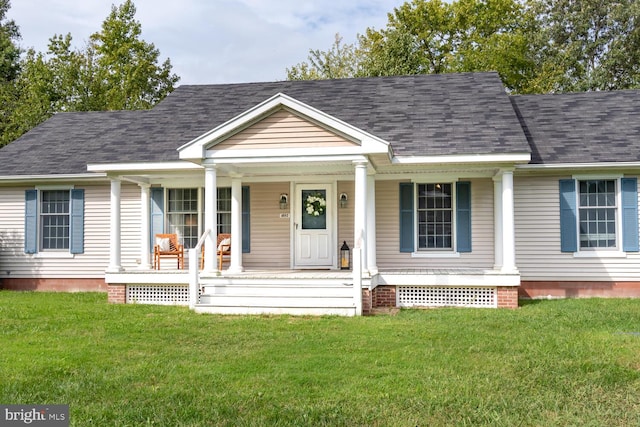 view of front of property with covered porch, roof with shingles, and a front lawn