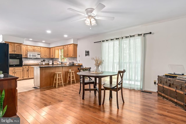 dining space featuring light wood-style flooring, ornamental molding, a ceiling fan, and recessed lighting