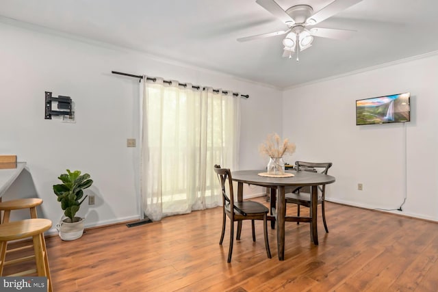 dining area with ornamental molding and wood finished floors