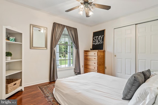 bedroom with crown molding, a closet, dark wood finished floors, and baseboards