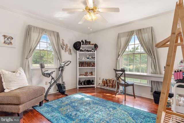 interior space with ceiling fan, ornamental molding, wood finished floors, and baseboards