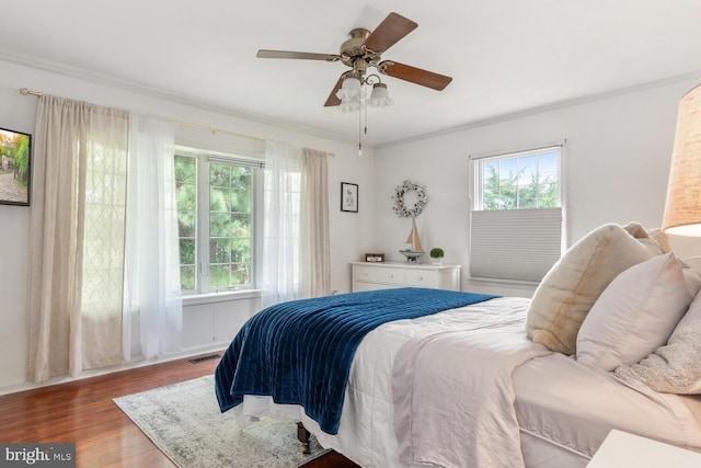 bedroom featuring wood finished floors, a ceiling fan, and crown molding