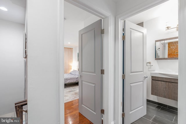 corridor with dark wood-style flooring and recessed lighting