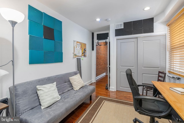 office space featuring recessed lighting, visible vents, baseboards, and wood finished floors