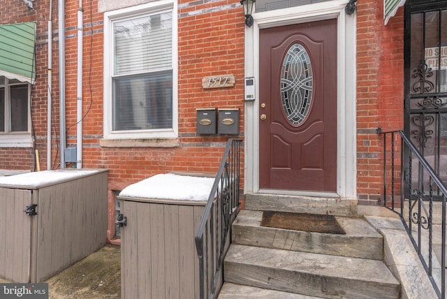 doorway to property with brick siding