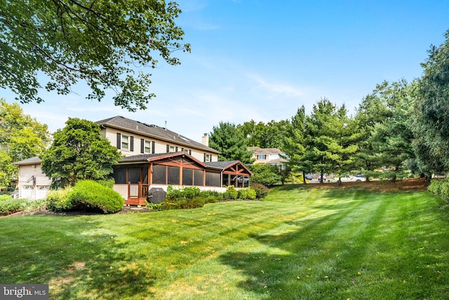 view of yard featuring a sunroom and an attached garage