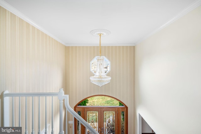 foyer with a chandelier, french doors, and ornamental molding