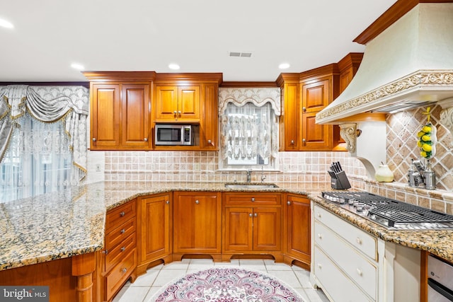 kitchen featuring visible vents, custom range hood, appliances with stainless steel finishes, a sink, and light tile patterned flooring