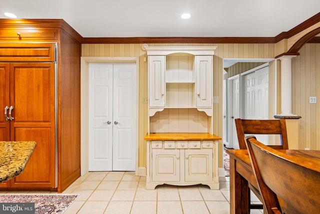 kitchen featuring light tile patterned floors, arched walkways, light stone counters, and recessed lighting