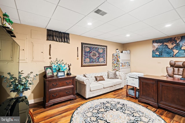 office space featuring a drop ceiling, recessed lighting, visible vents, baseboards, and light wood-type flooring