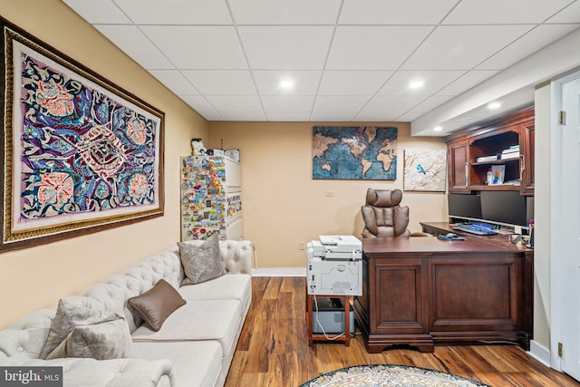 office with a paneled ceiling, baseboards, and wood finished floors