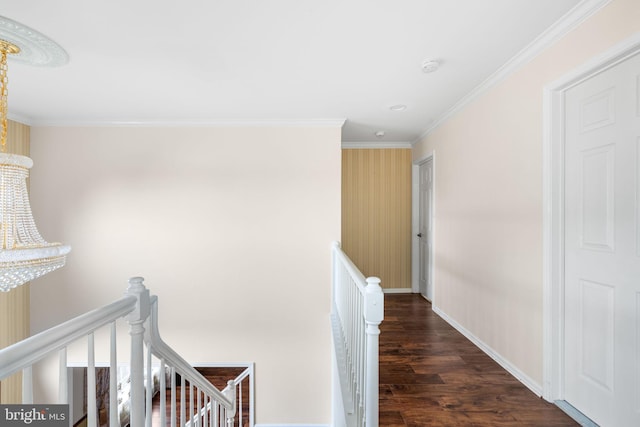 hallway with baseboards, wood finished floors, an upstairs landing, and crown molding